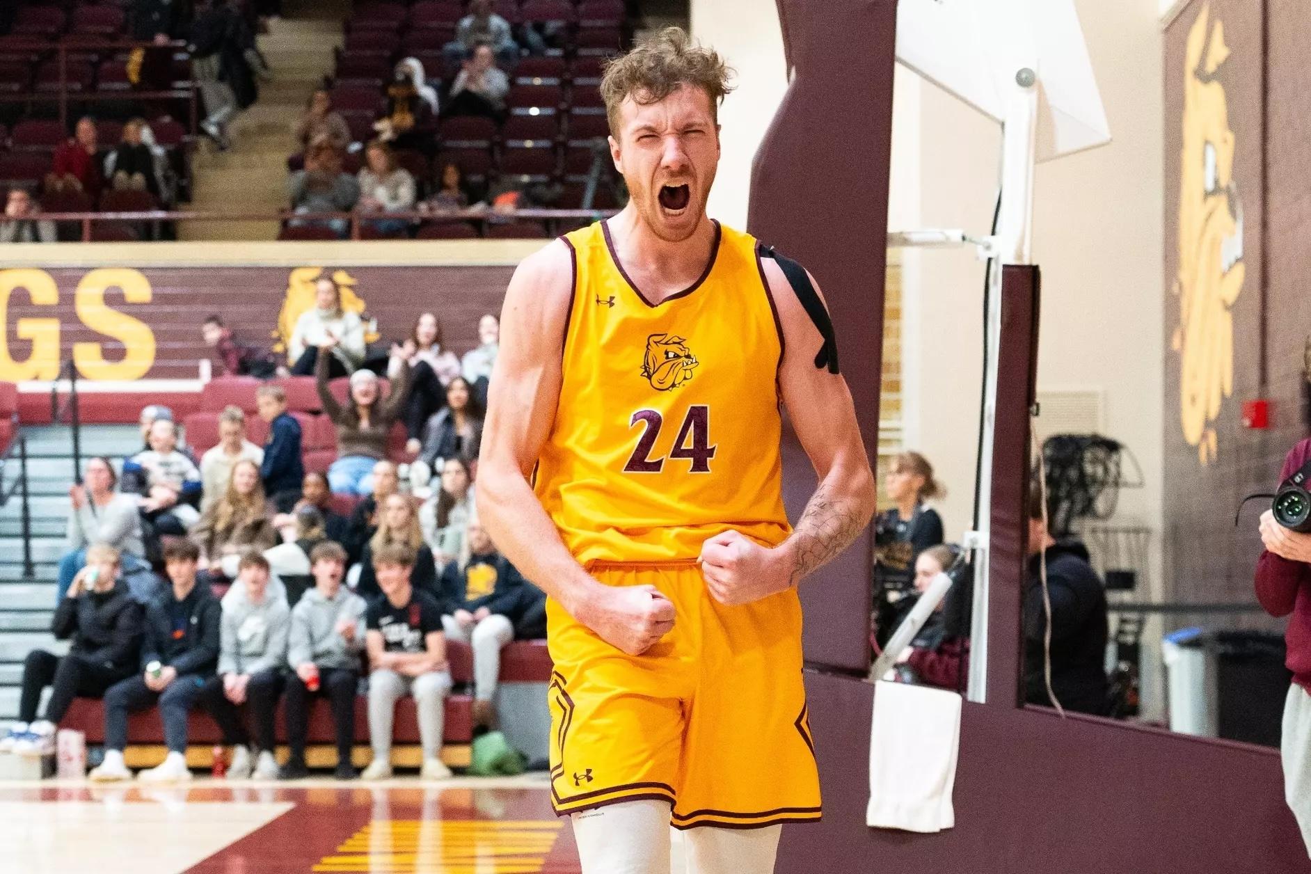 Minnesota Duluth player in away yellow jersey fist pumps and roars after another win.